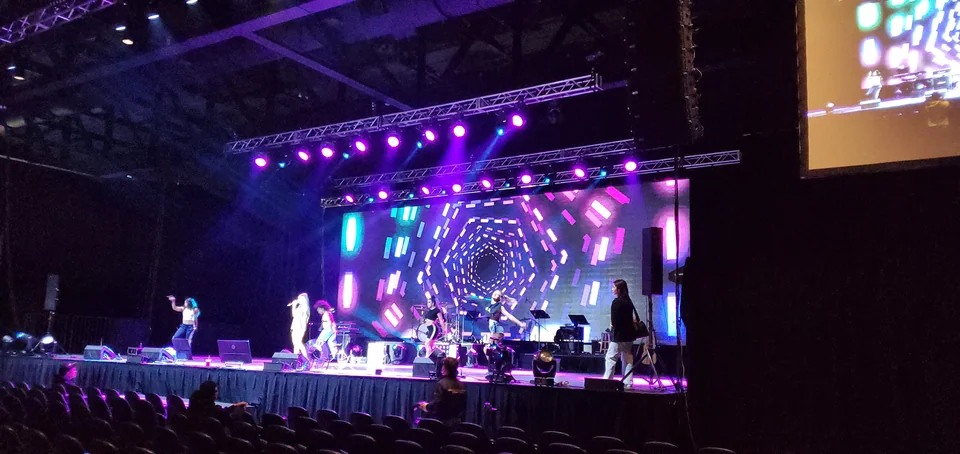 Angled view of the stage display and side-screen performance feed.
