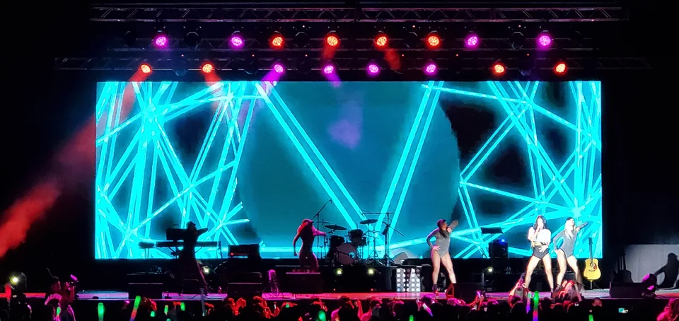 Cyan graphics across the stage display during a performance.