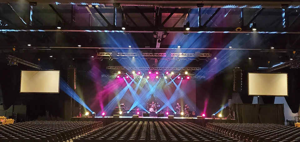 Wide view of the seating area, stage and overhead lighting.