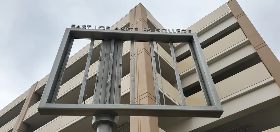 Exposed mounting frame beside a campus parking structure.
