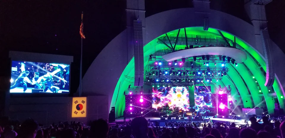 Nighttime visuals across the stage and side screen.
